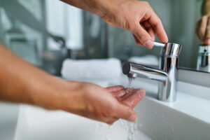 A hand placed under a running faucet.