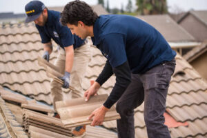 Lee's roofers placing tiles on roof.