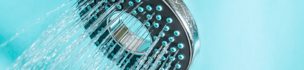 A close-up image of running water flowing out of a shower head